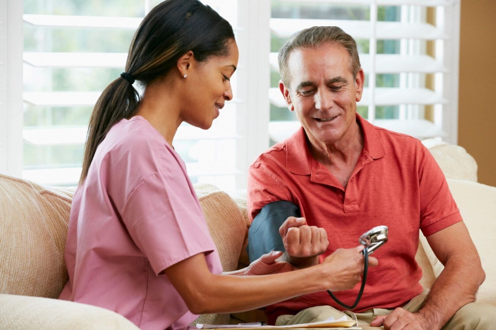 A lady holding a stethoscope and talking to a man